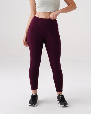 Woman wearing RYZ fleece-lined warm leggings in wine with deep side pockets