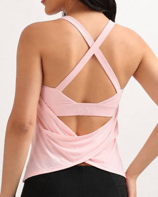 Woman wearing RYZ Original Swoosh padded cross-back wrap tank with built-in bra in baby pink, back view